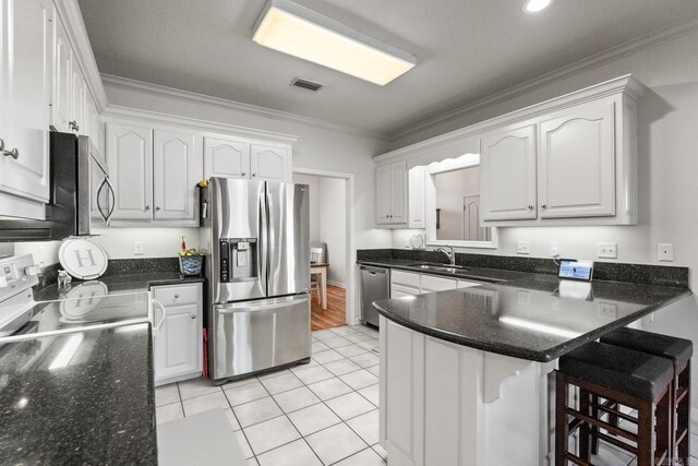 3720 Mcconnell Dr, Conway, AR 72034 - kitchen with appliances with stainless steel finishes, crown molding, a peninsula, white cabinetry, and a breakfast bar area