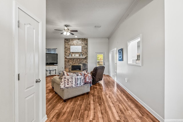 3720 Mcconnell Dr, Conway, AR 72034 - living area with wood finished floors, a ceiling fan, ornamental molding, a fireplace, and baseboards