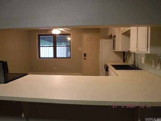 109 Indian Hls Unit C10, Hot Springs, AR 71913 - kitchen featuring a sink, decorative backsplash, light countertops, white cabinetry, and a ceiling fan