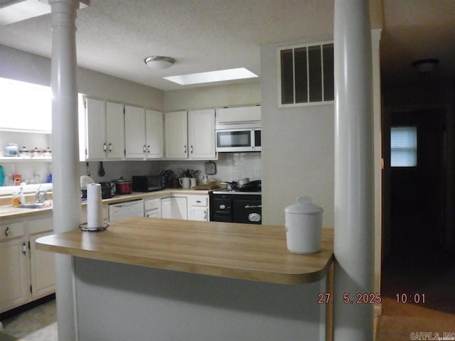 47 Segovia Dr, Hot Springs Village, AR 71909 - kitchen with stainless steel microwave, white cabinetry, decorative columns, and dishwasher