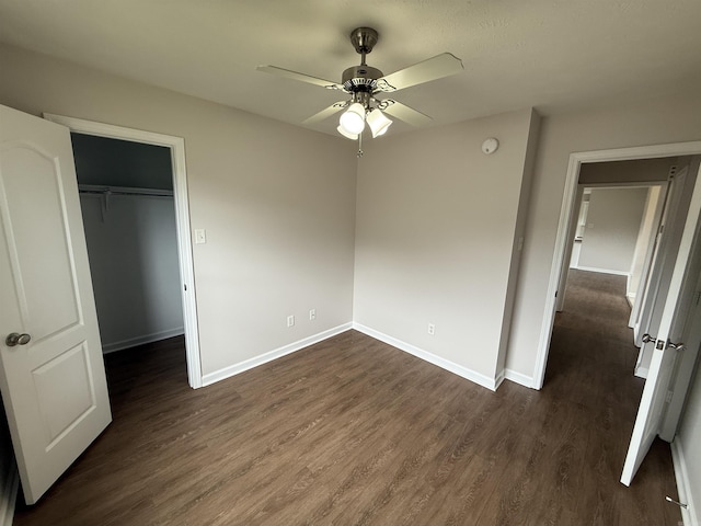 406 Apricot St, Austin, AR 72007 - unfurnished bedroom featuring dark wood finished floors, baseboards, a closet, a walk in closet, and ceiling fan