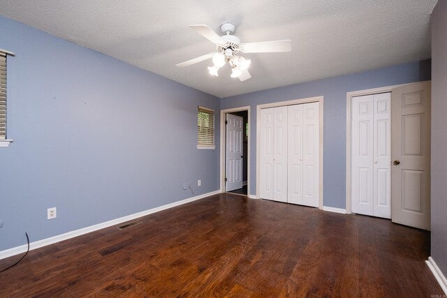 3400 Millbrook Rd, Little Rock, AR 72227 - unfurnished bedroom with multiple closets, baseboards, wood finished floors, and ceiling fan
