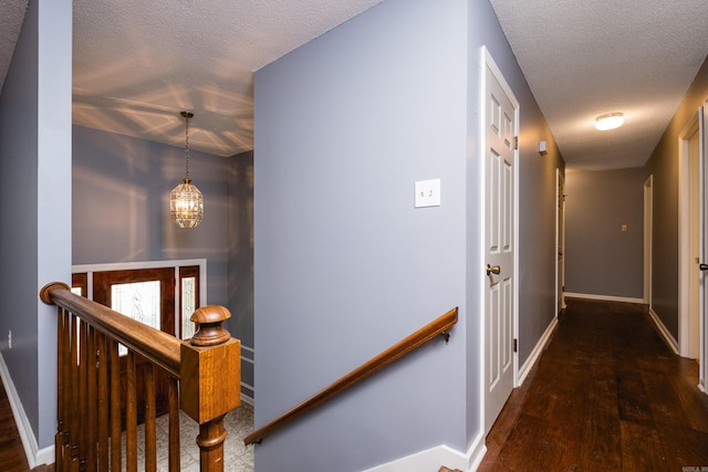 3400 Millbrook Rd, Little Rock, AR 72227 - hall featuring an upstairs landing, a textured ceiling, baseboards, wood finished floors, and a chandelier