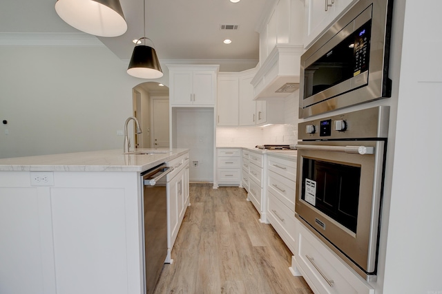 9 Quartz Cv, Little Rock, AR 72223 - kitchen featuring appliances with stainless steel finishes, a sink, crown molding, light wood finished floors, and white cabinets