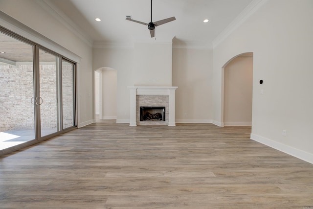 9 Quartz Cv, Little Rock, AR 72223 - unfurnished living room featuring arched walkways, a ceiling fan, a fireplace, light wood finished floors, and ornamental molding
