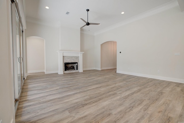 9 Quartz Cv, Little Rock, AR 72223 - unfurnished living room with arched walkways, ceiling fan, crown molding, light wood-style flooring, and a fireplace