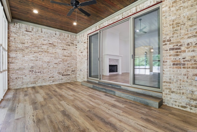 9 Quartz Cv, Little Rock, AR 72223 - spare room featuring brick wall, a ceiling fan, wooden ceiling, wood finished floors, and a fireplace