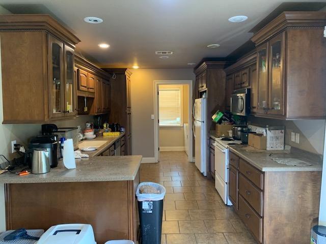 4709 Summit Rdg, Jonesboro, AR 72404 - kitchen with white appliances, glass insert cabinets, light countertops, and recessed lighting