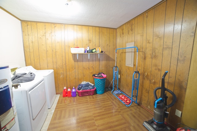 laundry area with separate washer and dryer, wooden walls, and water heater