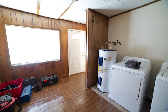 laundry area with washer and dryer, electric water heater, and wood walls