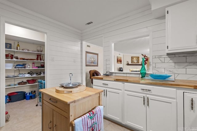 160 Cooper St Unit B11, Hot Springs, AR 71913 - kitchen with butcher block counters, light tile patterned floors, decorative backsplash, wooden walls, and ornamental molding