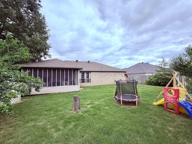 7 Butterfly Dr, Sherwood, AR 72120 - view of grassy yard with a trampoline, a sunroom, and a playground