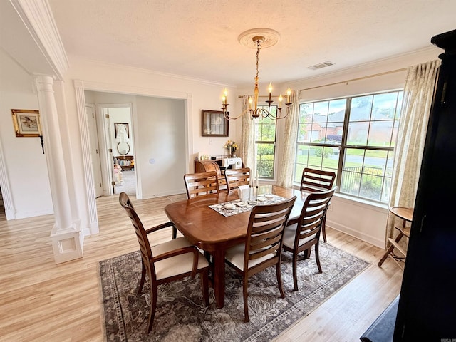 7 Butterfly Dr, Sherwood, AR 72120 - dining space featuring a chandelier, ornate columns, ornamental molding, light wood-type flooring, and baseboards