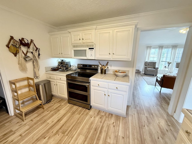 7 Butterfly Dr, Sherwood, AR 72120 - kitchen with double oven range, white microwave, light wood-style flooring, white cabinetry, and crown molding