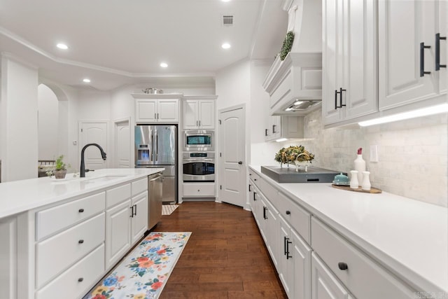 1517 Wetherborne Dr, Little Rock, AR 72211 - kitchen featuring appliances with stainless steel finishes, arched walkways, white cabinets, light countertops, and backsplash