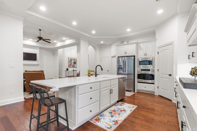 1517 Wetherborne Dr, Little Rock, AR 72211 - kitchen with appliances with stainless steel finishes, a tray ceiling, a sink, arched walkways, and ceiling fan