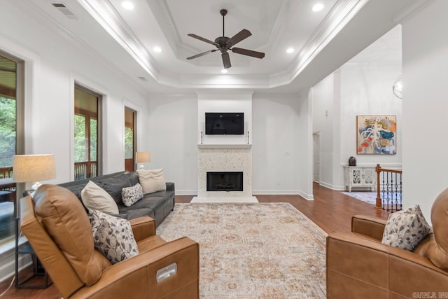 1517 Wetherborne Dr, Little Rock, AR 72211 - living room featuring ceiling fan, ornamental molding, wood finished floors, a raised ceiling, and a fireplace with flush hearth