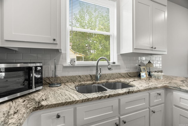 1 Park St Unit A & B, Mayflower, AR 72106 - kitchen with stainless steel microwave, a sink, white cabinetry, tasteful backsplash, and light stone counters