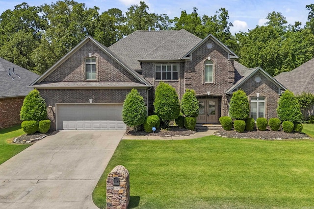 119 Marseille Dr, Maumelle, AR 72113 - traditional-style house featuring brick siding, french doors, a front lawn, concrete driveway, and roof with shingles