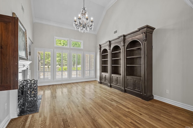 119 Marseille Dr, Maumelle, AR 72113 - unfurnished dining area featuring high vaulted ceiling, a chandelier, crown molding, wood finished floors, and baseboards