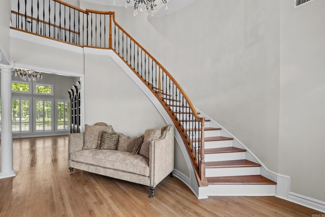 119 Marseille Dr, Maumelle, AR 72113 - staircase featuring a chandelier, a towering ceiling, wood finished floors, and baseboards