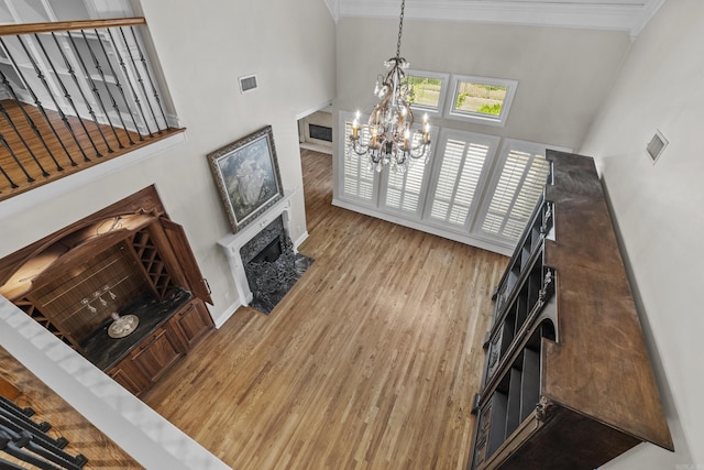 119 Marseille Dr, Maumelle, AR 72113 - living area with a towering ceiling, a chandelier, wood finished floors, a high end fireplace, and ornamental molding