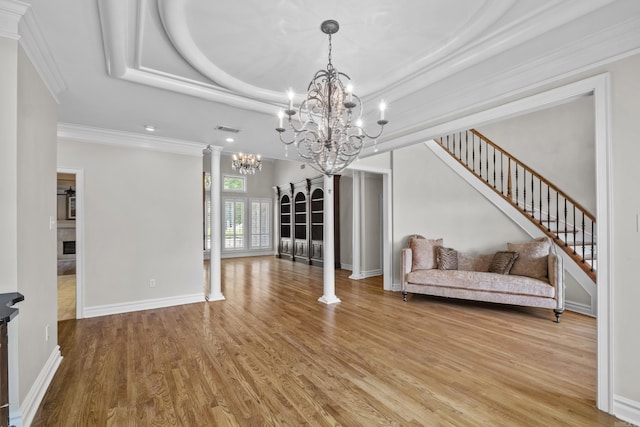 119 Marseille Dr, Maumelle, AR 72113 - living area featuring a chandelier, light wood finished floors, ornamental molding, a raised ceiling, and stairway