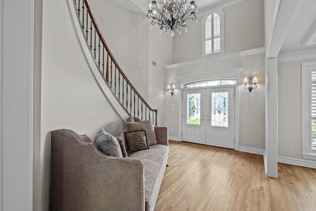 119 Marseille Dr, Maumelle, AR 72113 - foyer entrance featuring a chandelier, healthy amount of natural light, light wood-type flooring, stairway, and a high ceiling