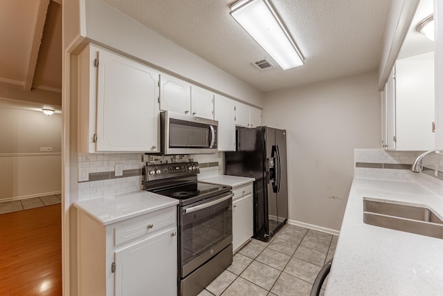 1655 Doe Trl, Conway, AR 72034 - kitchen with stainless steel appliances, a sink, white cabinets, tasteful backsplash, and baseboards