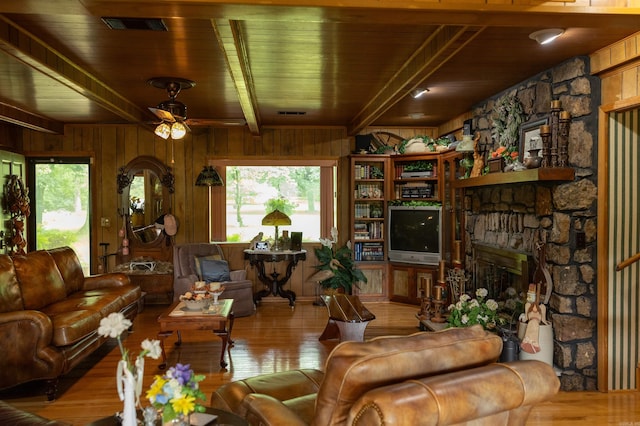 100 Rainbow Loop, Heber Springs, AR 72543 - living area with wooden ceiling with exposed beams, a ceiling fan, wood finished floors, a stone fireplace, and wood walls