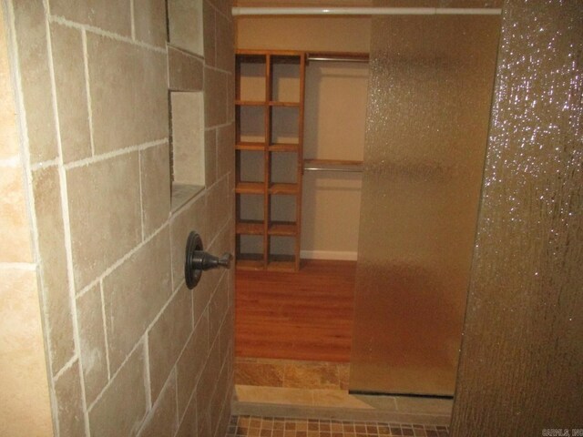 13 Cevico Ln, Hot Springs Village, AR 71909 - bathroom featuring a tile shower and wood finished floors