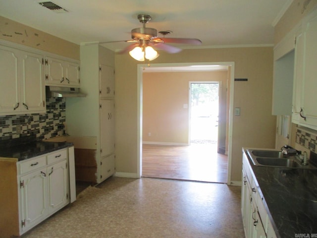 3908 S Hazel St, Pine Bluff, AR 71603 - kitchen with a sink, a ceiling fan, tasteful backsplash, dark countertops, and white cabinetry