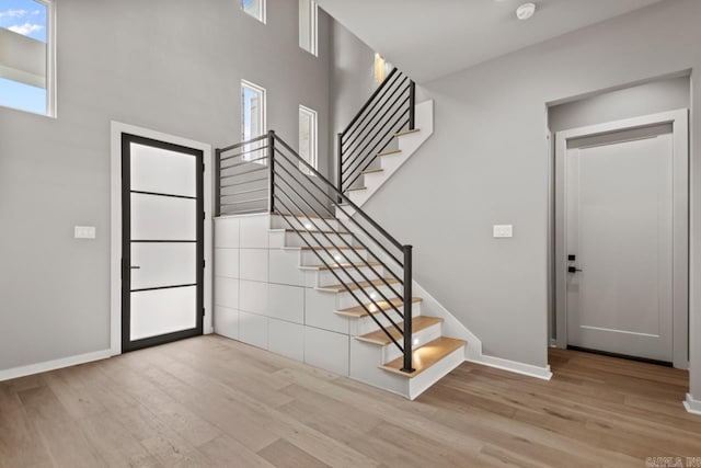 22 Abington Ct, Little Rock, AR 72223 - staircase featuring wood finished floors, baseboards, and a high ceiling