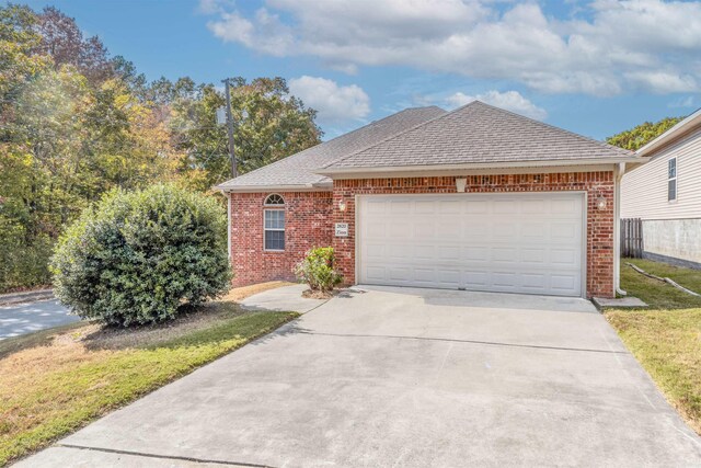 2820 Zion St, Little Rock, AR 72204 - view of front of property with brick siding, driveway, an attached garage, and roof with shingles