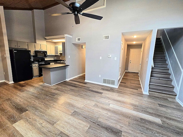 2715 Greenbriar Dr Apt B, Jonesboro, AR 72401 - kitchen featuring black appliances, dark countertops, baseboards, ceiling fan, and dark wood finished floors
