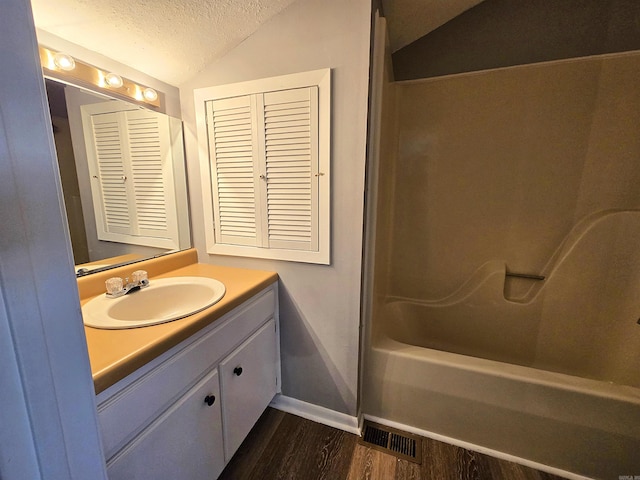 2715 Greenbriar Dr Apt B, Jonesboro, AR 72401 - bathroom with a textured ceiling, vanity, wood finished floors, baseboards, and lofted ceiling