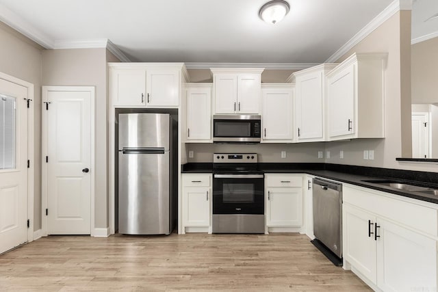 17 Woodhaven Dr, Cabot, AR 72023 - kitchen featuring stainless steel appliances, crown molding, dark countertops, white cabinetry, and light wood-type flooring
