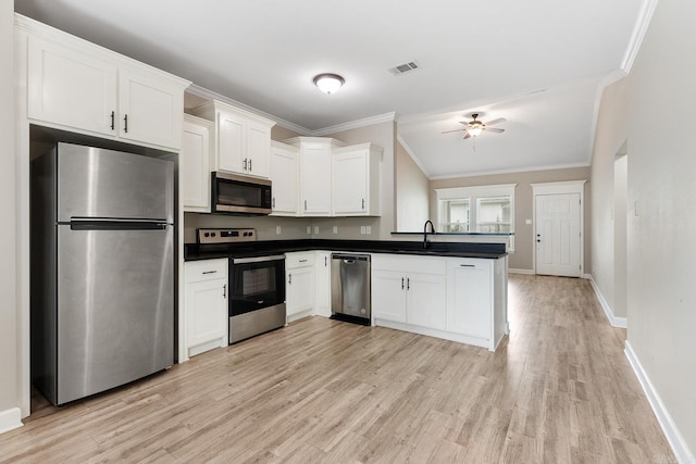 17 Woodhaven Dr, Cabot, AR 72023 - kitchen with appliances with stainless steel finishes, ornamental molding, dark countertops, ceiling fan, and light wood finished floors