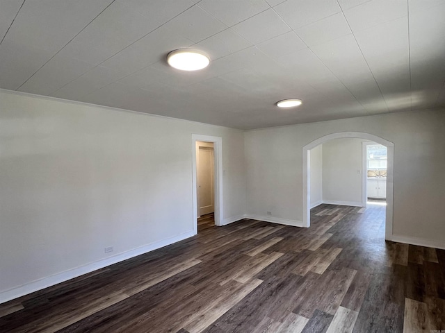 611 N Main St, Malvern, AR 72104 - unfurnished room with arched walkways, dark wood-style floors, and baseboards