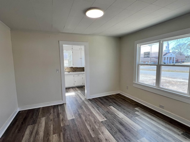 611 N Main St, Malvern, AR 72104 - spare room featuring dark wood-style flooring, baseboards, and ornamental molding