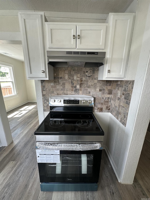 611 N Main St, Malvern, AR 72104 - kitchen with stainless steel electric range oven, under cabinet range hood, white cabinetry, tasteful backsplash, and dark wood-style floors