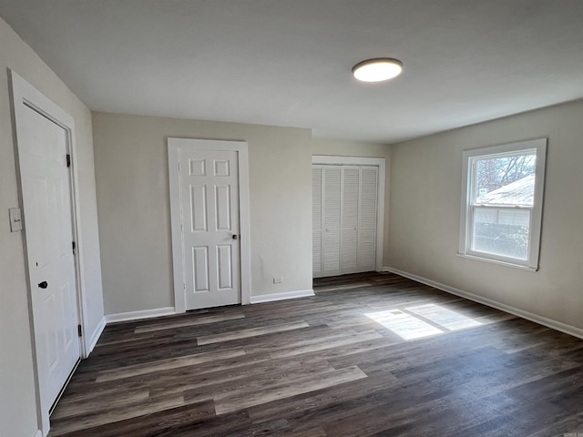 611 N Main St, Malvern, AR 72104 - unfurnished bedroom featuring a closet, baseboards, and dark wood-style floors