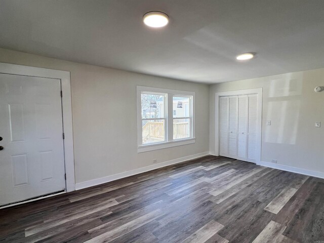 611 N Main St, Malvern, AR 72104 - unfurnished bedroom with dark wood-type flooring, baseboards, and a closet