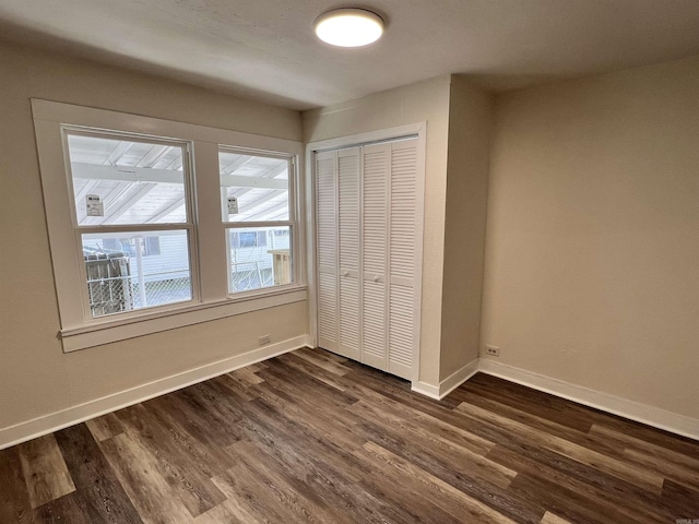 611 N Main St, Malvern, AR 72104 - unfurnished bedroom with baseboards, a closet, and dark wood finished floors