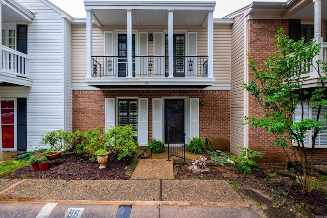 99 Kingsbridge Way, Little Rock, AR 72212 - view of front facade featuring a balcony, brick siding, and covered porch