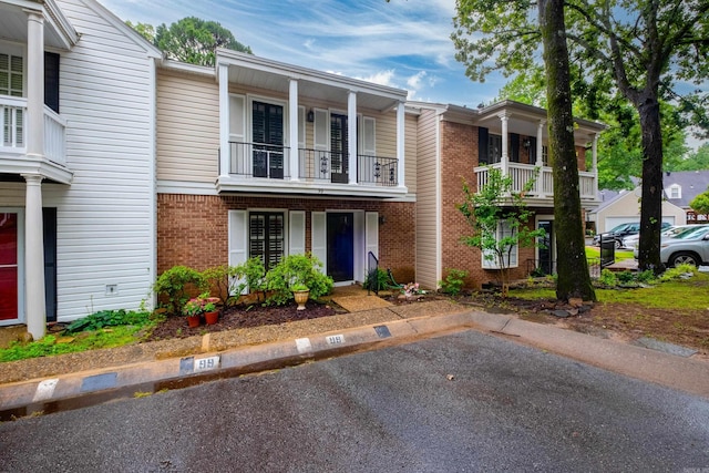 99 Kingsbridge Way, Little Rock, AR 72212 - view of property featuring brick siding, a balcony, and uncovered parking
