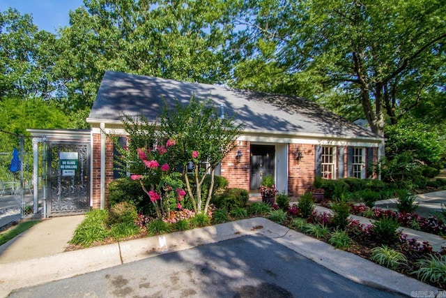 99 Kingsbridge Way, Little Rock, AR 72212 - view of front of home with brick siding, a gate, a carport, and roof with shingles