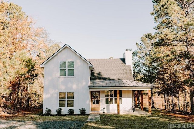 2441 Miller County 77, Doddridge, AR 71834 - view of front of property featuring a standing seam roof, a front lawn, metal roof, a chimney, and a porch