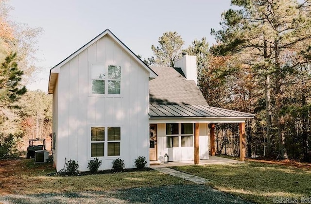 2441 Miller County 77, Doddridge, AR 71834 - view of front of home with board and batten siding, a standing seam roof, a front lawn, a chimney, and metal roof