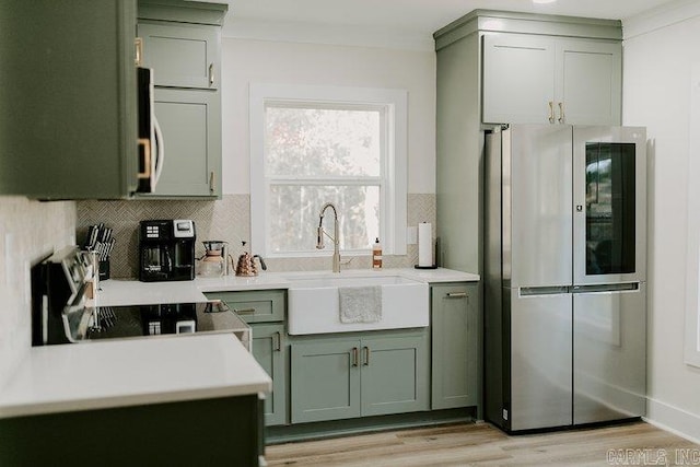 2441 Miller County 77, Doddridge, AR 71834 - kitchen featuring appliances with stainless steel finishes, green cabinetry, a sink, tasteful backsplash, and ornamental molding